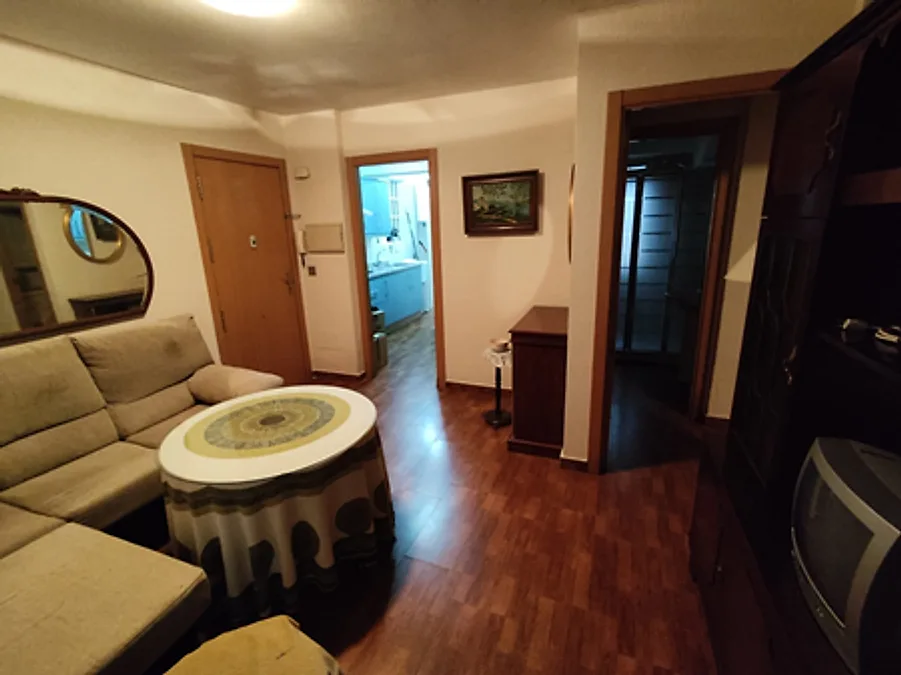 Salón con sofá y mesa camilla – Venta Piso Carretera Trassierra Córdoba
