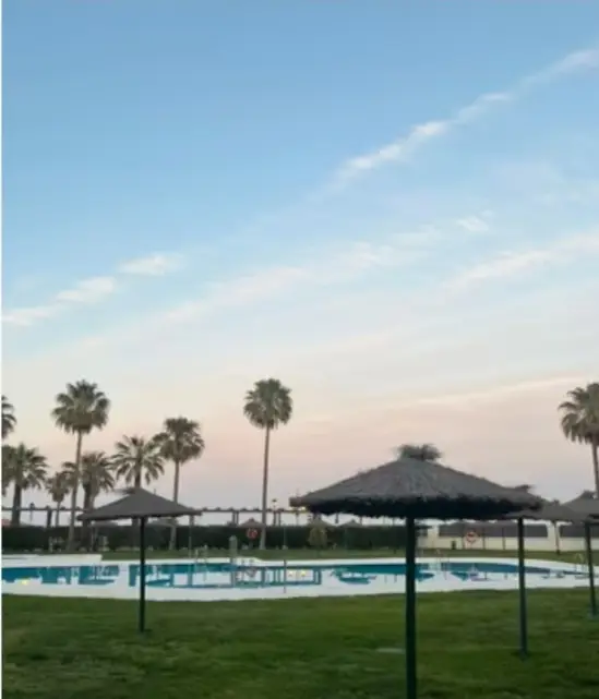 Piscina con sombrillas al atardecer – Venta de apartamento en La Noria con piscina