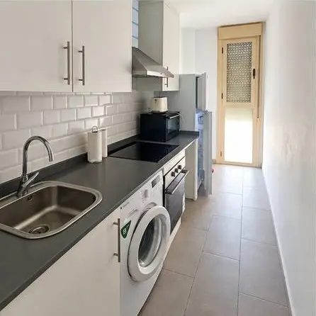 Cocina con lavadora, horno y vitrocerámica del apartamento en Ciudad Jardín
